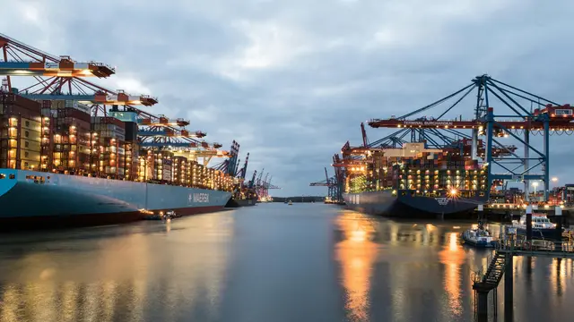 Buque portacontenedores operando en un puerto al atardecer